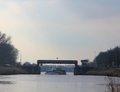 In de verte, onder de hefbrug tussen Noord- en Zuidhorn op het Van Starkenborghkanaal, nadert de Linquenda.